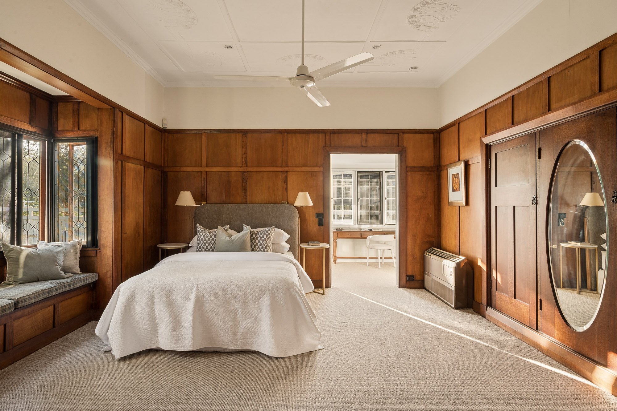 Timber-lined main bedroom with leadlight windows and adjoining sunroom
