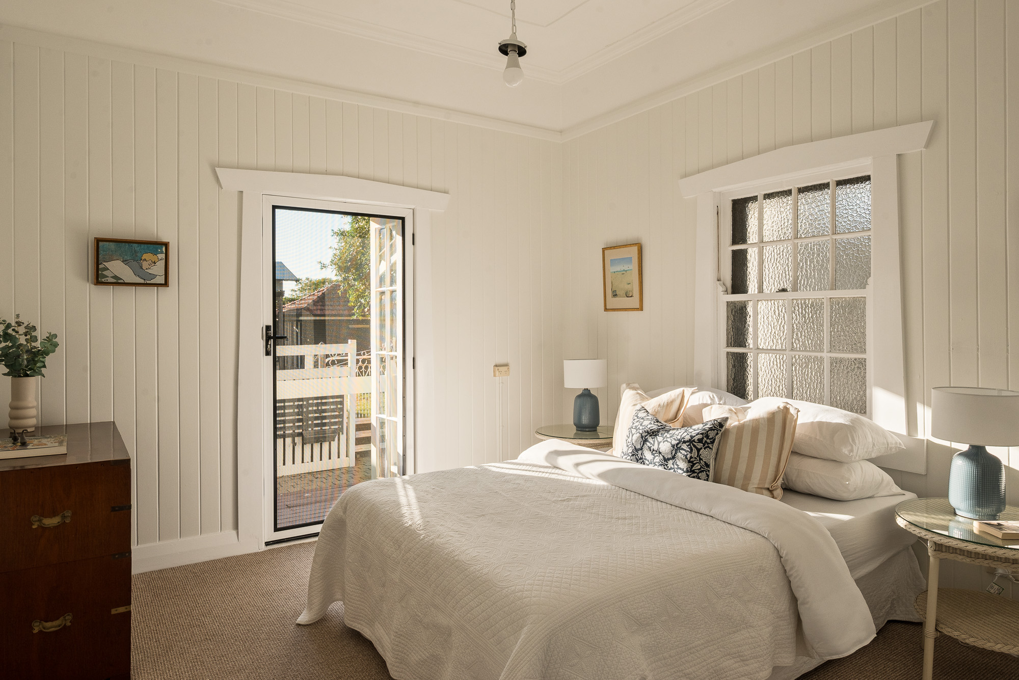 White VJ-lined bedroom with private balcony access